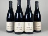 four bottles of wine are lined up on a table