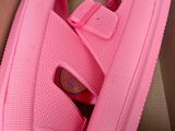 pink shoes in a box on top of a desk with a keyboard