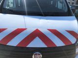 a white van with red stripes parked in a parking lot