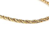 a close up of a gold necklace on a white surface