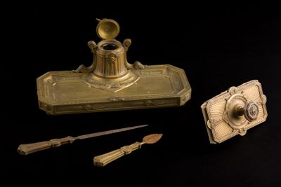 un encrier en or, avec une plume et un couteau à côté