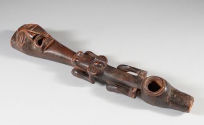 une image représentant une pipe en bois sur laquelle est sculpté un visage