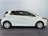 the small white car is parked in a room with a gray floor