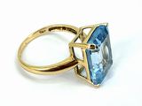 an image of a gold ring with a blue topaz stone