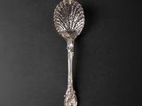 a close up of a silver spoon on a black surface