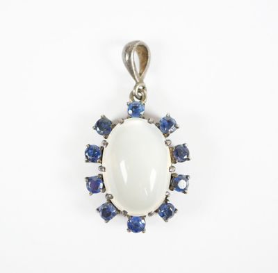 un pendentif en oplite blanche serti de saphirs bleus et de diamants