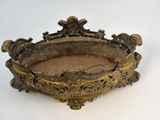 an antique brass bowl with ornate decoration on a white surface