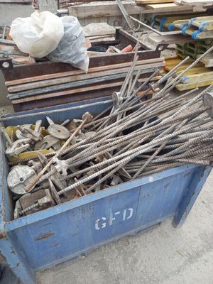 un conteneur bleu rempli de barres d'acier et d'autres outils