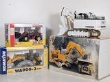 two boxes of toy construction vehicles on a table