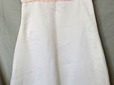 the dress is white and has pink trimmings on it