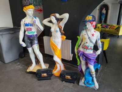 trois statues représentant un homme et une femme sur des skateboards