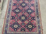 a pink rug with blue and red designs on it
