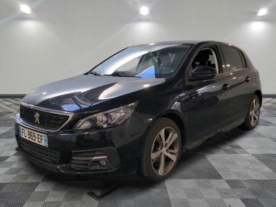 la voiture noire est garée sur un sol en damier dans le garage