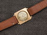 un gros plan d'une montre montée sur un bracelet en cuir marron