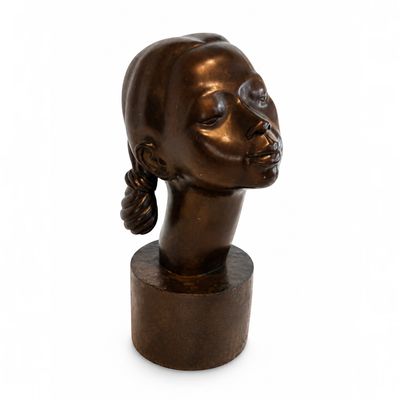 sculpture d'une tête de femme sur une base en bois