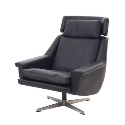 La chaise est en cuir noir et possède un piètement en métal.