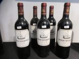 quatre bouteilles de vin sont alignées sur un comptoir