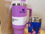 a purple mug and a blue and pink mug on a table