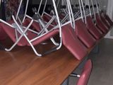 many chairs that are sitting around a long wooden table