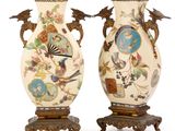 pair of vases with birds and flowers painted on them on stands