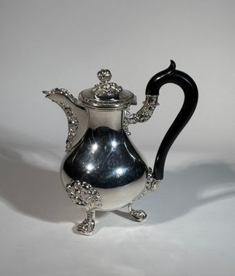 une théière en argent avec une anse noire sur un fond blanc