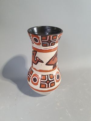 a small vase with a design on it on a table
