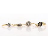 three gold rings with black and white diamonds on a white surface