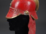 a red helmet with gold accents on a mannequin head