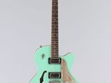 une guitare électrique au corps vert sur fond blanc