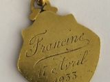a close up of a gold plated pendant with writing on it