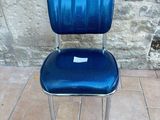 a blue chair that is sitting on a tile floor