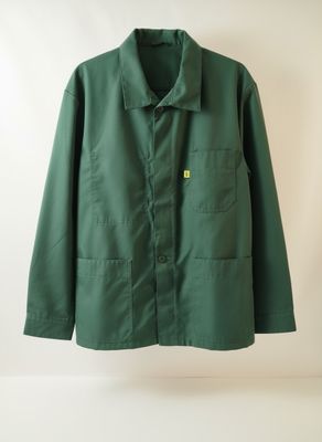 La veste verte est suspendue à un cintre accroché au mur.