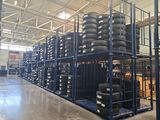 a lot of tires stacked on a rack in a warehouse