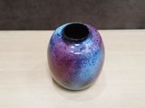 a purple and blue vase sitting on a wooden table