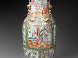 a vase with a painting on it sitting on a table