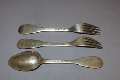 four forks and spoons are lined up on a table