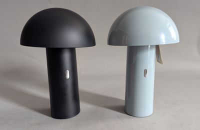 two black and white lamps sitting next to each other on a table