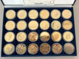 an assortment of gold and silver coins in a blue box