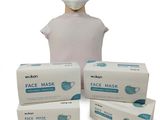 trois boîtes de masques faciaux et une tête de mannequin sur fond blanc