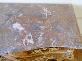 a marble top table with gold decorations on top of it