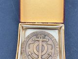 une photo représentant une médaille dans un coffret posé sur une table