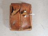 a brown leather case with two buttons on it