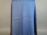 the back of a blue shawl with writing on it on a mannequin stand