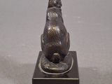 statue of a rabbit sitting on a base on a gray surface