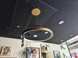 une photo d'une pièce avec un ventilateur de plafond et des tableaux accrochés au mur