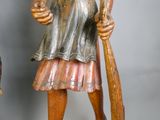 une statue en bois représentant un homme tenant une batte de baseball