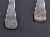 pair of silverware spoons and fork on a black surface
