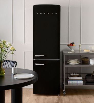 un réfrigérateur noir posé dans une cuisine, à côté d'une table