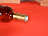 a bottle of wine sitting on a table with a red table cloth