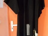 une robe noire accrochée au mur près d'une porte